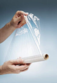 Stock Photo of man holding a sheet of clear plastic wrap