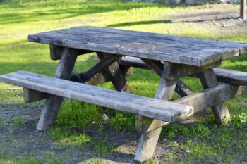 Image of a well used wooden picnic table in the park