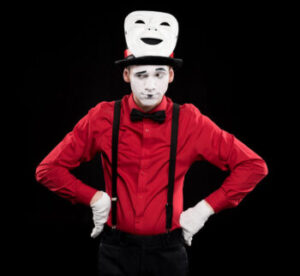 Grimacing mime with hands akimbo and mask on head