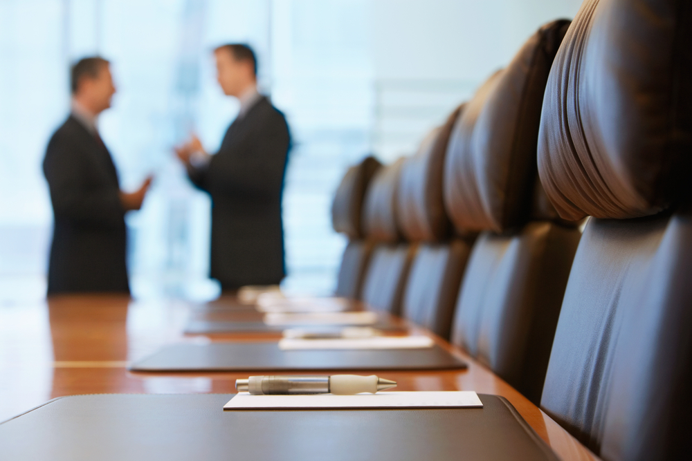 Two businessmen talking in conference room